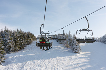 Fototapeta na wymiar Ski lift with people at ski resort. Sunny day