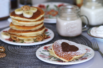 Breakfast pancakes served with honey and fruits and milk