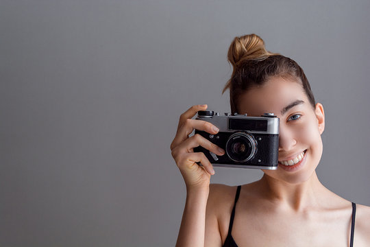 Image of cute girl make a photo selfie at vintage camera. Take a photograph of herself. Beauty. Happy girl smiling.