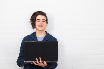 young man with computer isolated in white wall