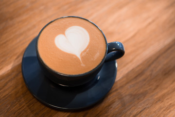 cappuccino with milk foam in a heart shape on wooden background.copy spase