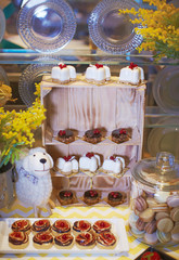 Concept candy bar with felted toy labs decorated with fresh berry cupcakes