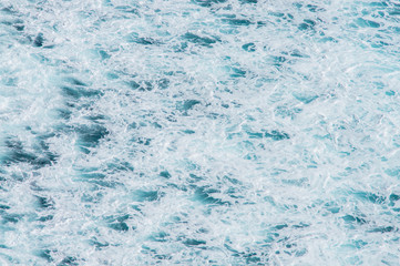 Texture of the Ocean. Natural background of blue-green sea water with foam