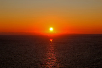 Fototapeta premium Beautiful sunset over the sea. The sun has a beautiful orange and red color.