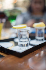 shot glass filled with tequila service with lemon and salt