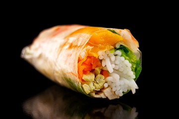 Closeup image of goi cuon spring rolls with shrimps, onion, mango, pork and noodles isolated at black background. Traditional vietnamese food.