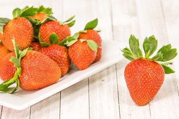 Strawberries on a plate and a wooden board