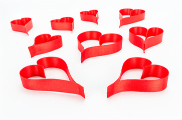 Heart made from red, satin ribbon on white background with clipping path. Valentines Day concept.