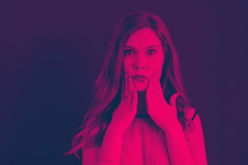 A girl holds her mouth with her hands pink and blue duotone