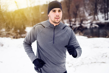 Young Man running, training for the Ultra trail Marathon in winter day