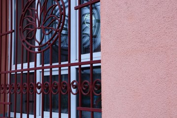 red forged bars on the window and part of the concrete wall