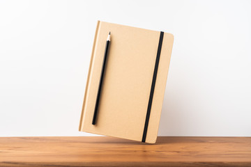 Perspective view of kraft notebook on wood floor