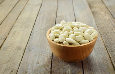 white bean in a bowl on a wooden background