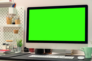 Loft workspace with green screen desktop computer