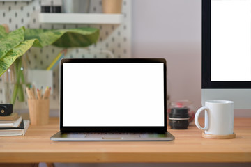 Fototapeta premium Loft wood office desk table with laptop, poster, coffee mug and supplies.