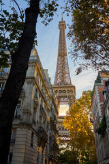 Eiffel Tower Shot Between Typical Parisian Style Buldings And Tr