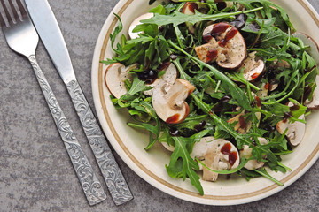 Healthy Arugula Salad with Raw Champignons with Olive Oil and Soy Sauce Vegan salad with raw mushrooms.