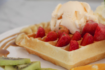 waffle with strawberry topping and ice cream.