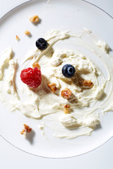 Whipping cream,nuts and berries on plate