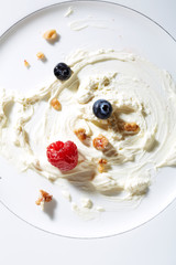 Whipping cream,nuts and berries on plate