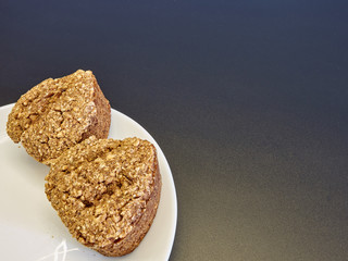high-quality bread from sprouted wheat heart shape on a white plate of Chinese porcelain on a black background in the corner of the frame. homebaked bread. healthy food. breakfast