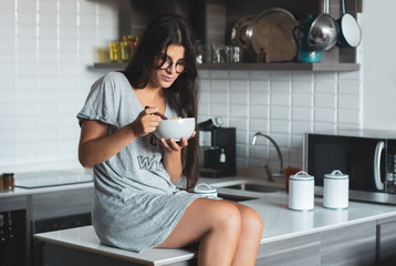 Young woman having breakfast in the kitchen