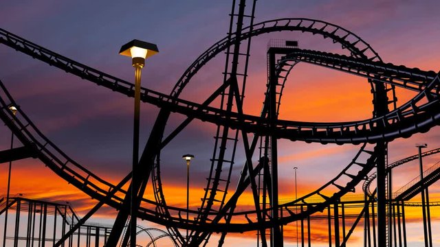roller coaster thrill ride at amusement park during sunset with car on track - 3d animation.