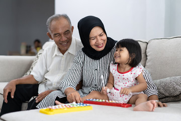 Fototapeta premium portrait of happy asian grandparent having fun with grandchild at home