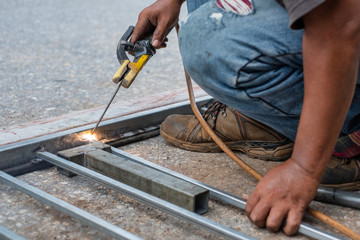 A welder is welding steel for house's fence