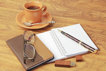 Notepad, fountain pen, glasses, cup of coffee.