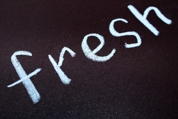 the word fresh is written with chalk diagonally on a magnetic board