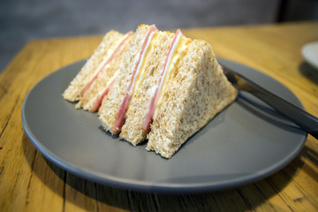 Whole wheat sandwich toast with ham and cheese on a wooden table at coffee shop