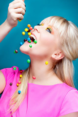 Obraz na płótnie Canvas beautiful blond girl with many colorful candies