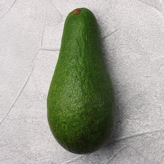 avocado on cement background. whole avocado top view