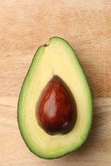 half avocado on wooden background top view
