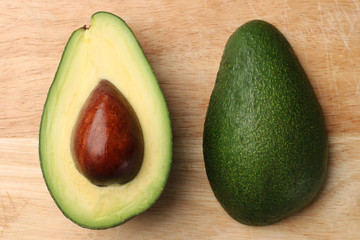 half avocado on wooden background top view
