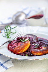Curd pancakes with cherry sauce with rosemary.