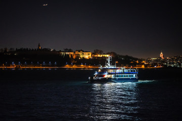 Ferry moves on waters of Bosphorus on background of Topkapi saray