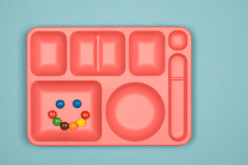 colorful chocolate candy pills in tray on blue background