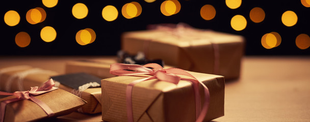 gift boxes with a blurred lights bokeh on dark background, long banner