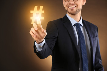 Young businessman using virtual screen on color background