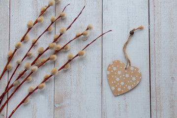 willow branches on a wooden table with a heart, a symbol of Easter, palm Sunday.Top view