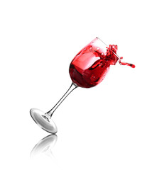 Falling glass with red splashing wine on white background