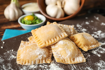 Plate with uncooked ravioli on table, closeup
