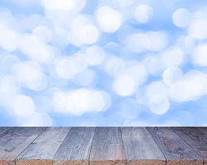 Empty wooden table top on blurred backdrop, blue cold background.