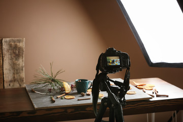 Professional photo camera near composition on table in studio