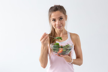 People, healthy lifestyle and fitness concept - Beautiful young woman after workout eating healthy salad