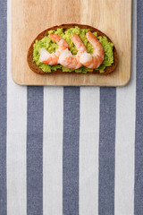 sandwich with shrimp and avocado on wood. breakfast concept