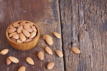 Almond nut in wooden bowl on classic wooden table background