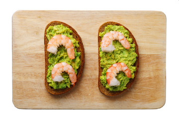 sandwich with shrimp and avocado isolated on white. healthy breakfast on wood